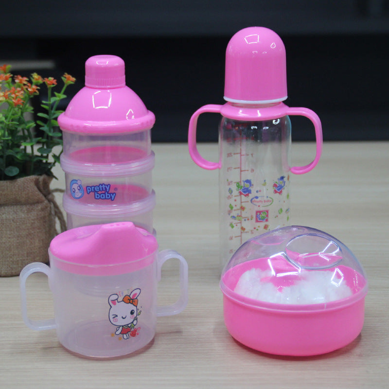 Set of baby bottles and containers with pink lids on a wooden surface.